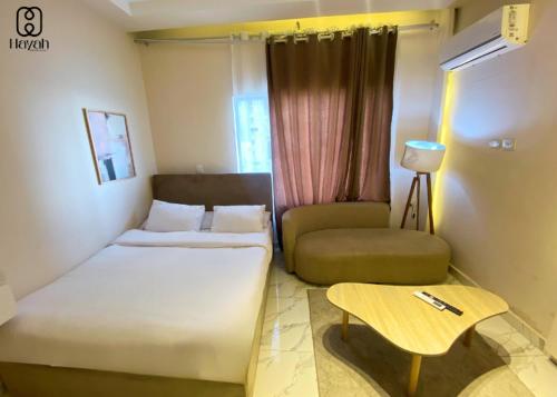 a room with a bed and a couch and a table at Hayah Waterfalls Hotels in Alexandria