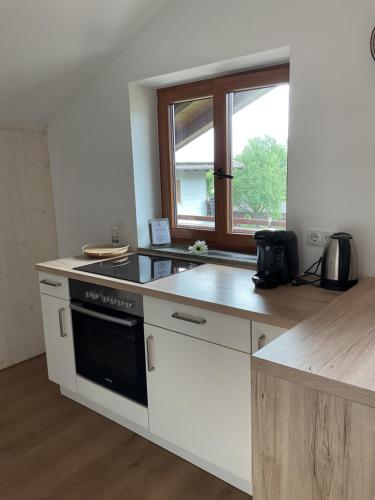a kitchen with a stove and a window at Sonnenaufgang in Rottau