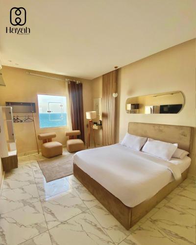 a bedroom with a large white bed in a room at Hayah Waterfalls Hotels in Alexandria