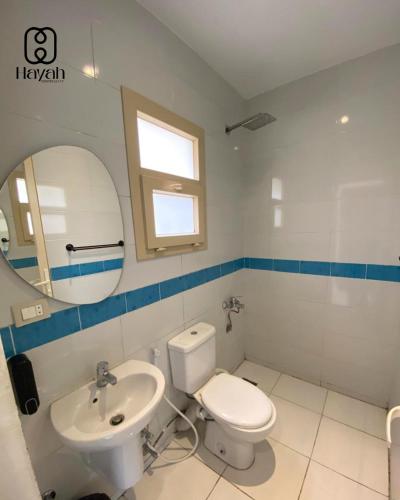 a bathroom with a toilet and a sink and a mirror at Hayah Waterfalls Hotels in Alexandria