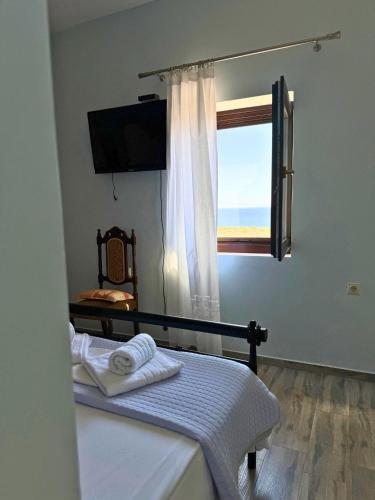 a bedroom with a window and a bed with towels at Armenopetra View Gerolimenas in Gerolimenas
