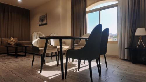 a dining room with a table and chairs and a window at Milan Park Hotel in Taif