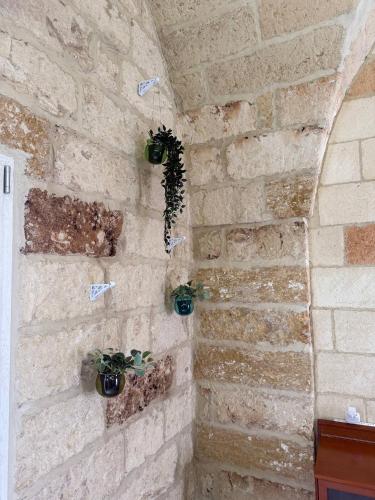 a stone wall with potted plants on it at Largo Spani 15 in Veglie