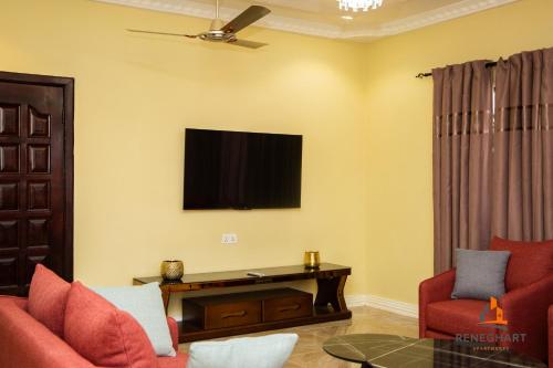 a living room with a tv on the wall at ReneGhart Apartments in Kasoa