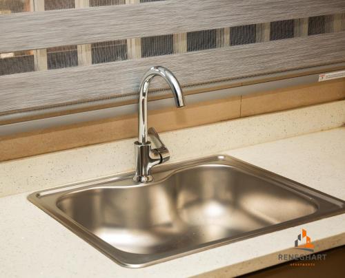 a stainless steel sink in a kitchen next to a window at ReneGhart Apartments in Kasoa