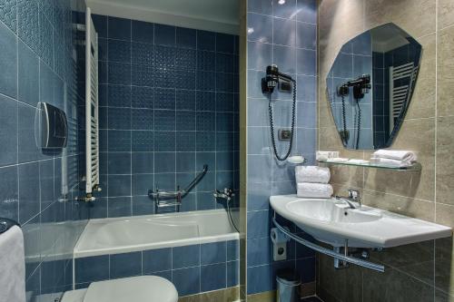 a bathroom with a sink and a tub and a toilet at BV Grand Hotel Assisi in Assisi