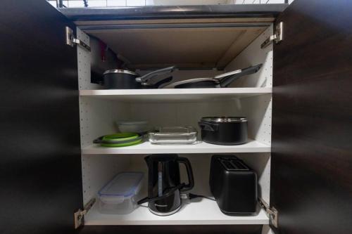 a cupboard filled with lots of kitchen utensils at Outdoor Sauna Hot Tub Playroom Port Dallhousie in St. Catharines