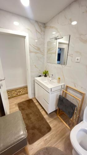Un baño con un lavabo blanco y un espejo. en Os Pimentinhas, 