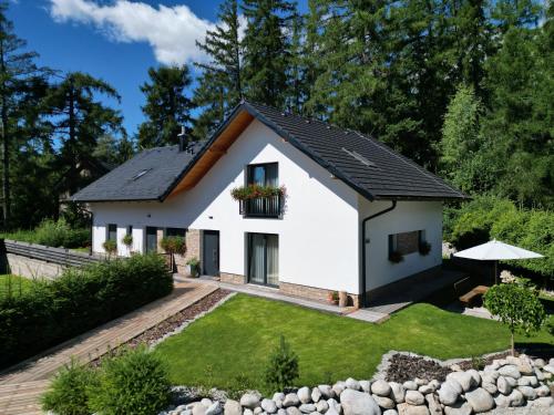 a white house with a black roof at Apartmány Runi in Stará Lesná