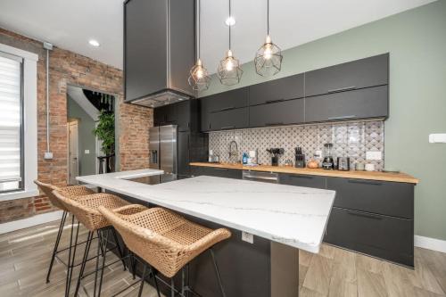 a kitchen with a counter and stools in it at The Baymiller Row - For 6 in Cincinnati