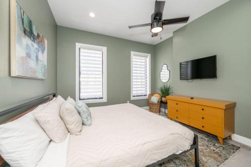 a bedroom with a bed and a dresser and a tv at The Baymiller Row - For 6 in Cincinnati