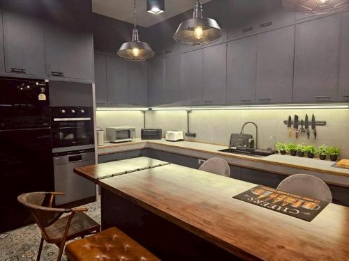 a kitchen with a wooden table and chairs in it at Black Sheep House Khaoyai by ALPHATEL PARTNER in Pong Talong