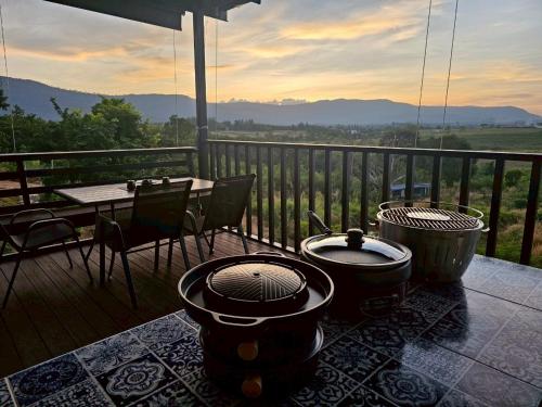 a deck with a table and a grill on a balcony at Black Sheep House Khaoyai by ALPHATEL PARTNER in Pong Talong