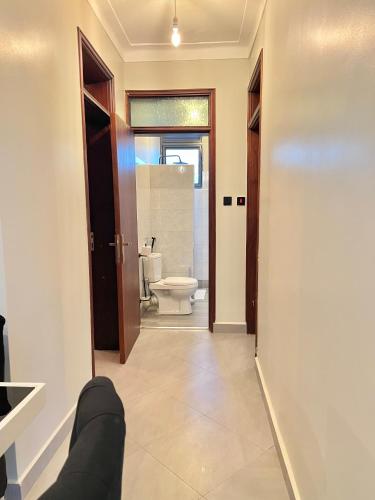 a room with a bathroom with a toilet and a sink at Vibe Apartments in Kampala