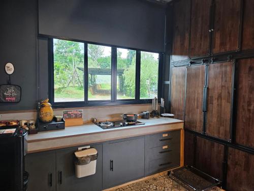a kitchen with a sink and a window at Black Sheep House Khaoyai by ALPHATEL PARTNER in Pong Talong