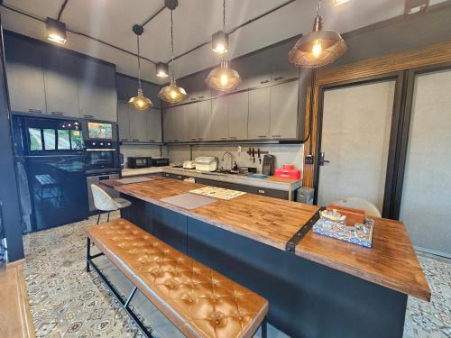 a kitchen with a wooden counter top in a room at Black Sheep House Khaoyai by ALPHATEL PARTNER in Pong Talong