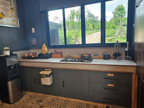a kitchen with a sink and a window at Black Sheep House Khaoyai by ALPHATEL PARTNER in Pong Talong