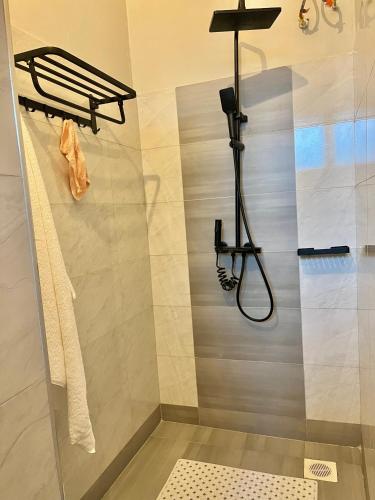 a bathroom with a shower with a towel rack at Vibe Apartments in Kampala
