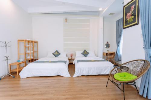 Una habitación con dos camas y una silla dentro. en TamThuanHome, en Nha Trang