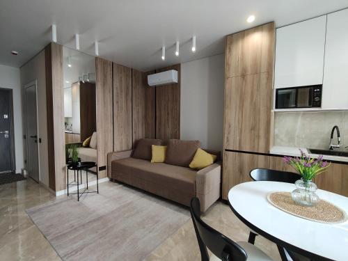 リヴィウにあるДизайнерські 2 кімнатні апартаменти Стрийськаのソファとテーブルのあるリビングルーム