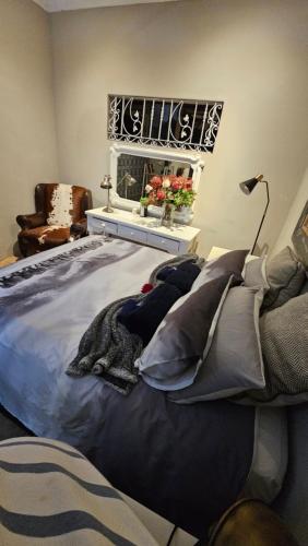 ein Schlafzimmer mit einem Bett mit Kissen und einem Fenster in der Unterkunft Rose Cottage in Pretoria