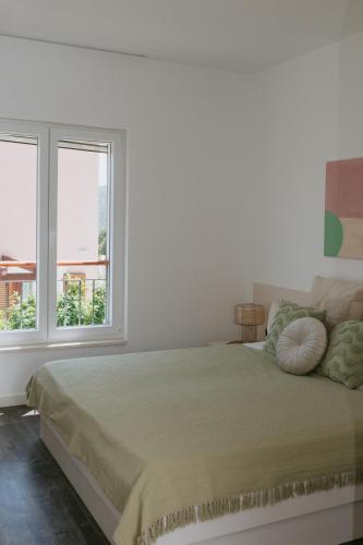a white bedroom with a bed and two windows at Villa Aurelia by Domus Mirus - Rooftop Cinema & Pool & 6 Minute Walk to Beach in Splitska