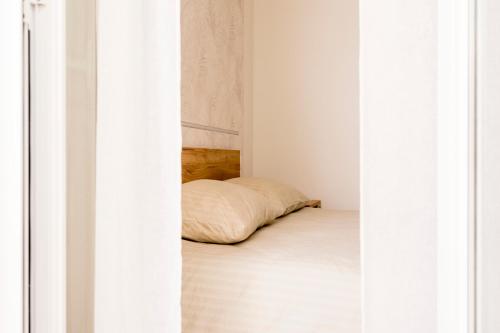a bed in a white room with a pillow at NonnaLo' bed and breakfast in Verbicaro