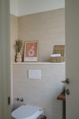 a bathroom with a toilet and a picture on a shelf at Villa Aurelia by Domus Mirus - Rooftop Cinema & Pool & 6 Minute Walk to Beach in Splitska