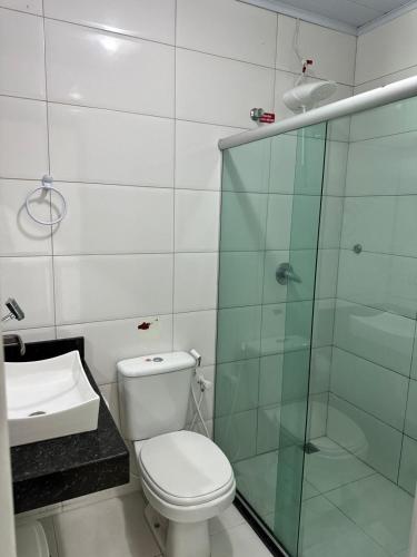 a bathroom with a toilet and a glass shower at Colorado Hotel in Eunápolis