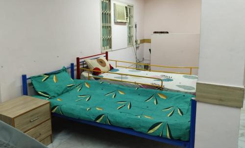 a bedroom with two beds with a green comforter at WISHTREE CORPORATE MENS DORMITORY FOR TECHIES AND Trainees in Chennai