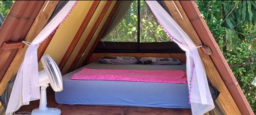 a bed in a tent with a window at Cabana 1 camping Dona Aurora Praia do Sono in Paraty