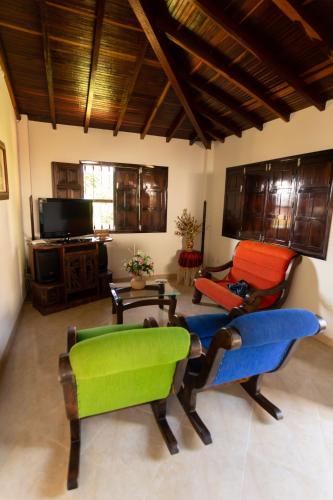 sala de estar con sillas coloridas y TV en Condominio Parque Baviera, en Barichara