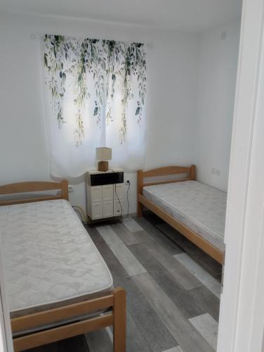 a room with two beds and a table in it at House&mini-Camp SKELICA in Neštin
