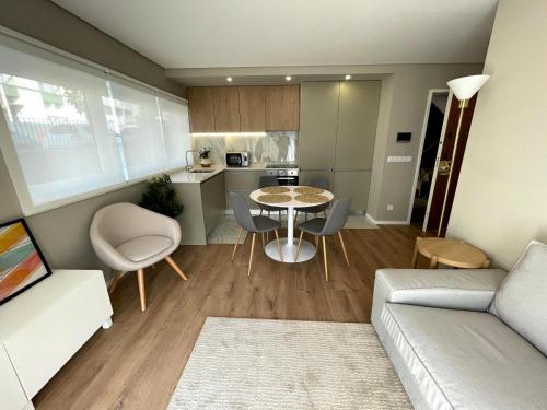 a living room with a couch and a table and chairs at Apartamento Parque da Cidade in Porto