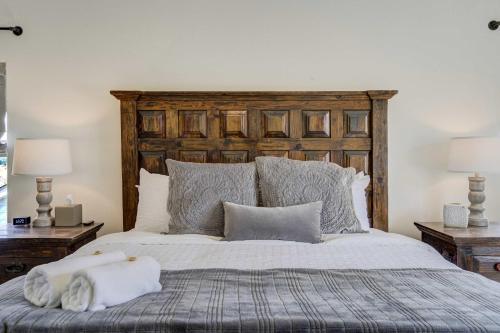 a bedroom with a bed with a wooden headboard and pillows at Highpoint Hills Great Views w Games & Fitness in Colorado Springs