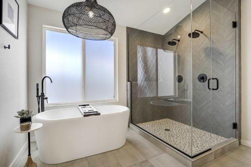 a bathroom with a white tub and a shower at Highpoint Hills Great Views w Games & Fitness in Colorado Springs