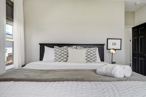 a bedroom with a large white bed with a window at Highpoint Hills Great Views w Games & Fitness in Colorado Springs