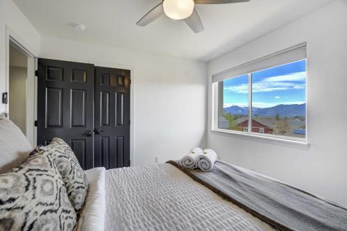 a bedroom with a bed with a ceiling fan and a window at Highpoint Hills Great Views w Games & Fitness in Colorado Springs