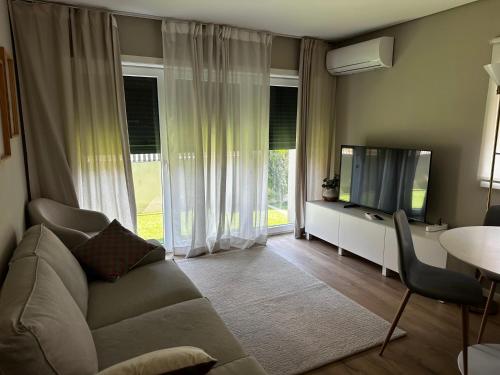 a living room with a couch and a tv and a table at Apartamento Parque da Cidade in Porto