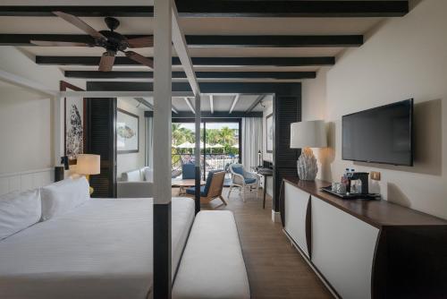 a hotel room with a bed and a tv at Ocean Riviera Paradise All Inclusive in Playa del Carmen