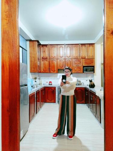 a woman standing in a kitchen taking a picture at Vilca Caldas in Moyobamba