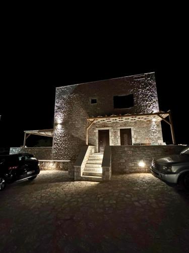 a brick building with a car parked in front of it at night at Armenopetra View Gerolimenas in Gerolimenas