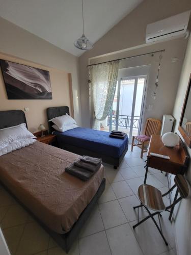 a bedroom with two beds and a table and a desk at Διαμέρισμα "LENIA" μπροστά στην θάλασσα! in Kiaton