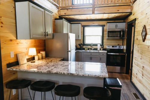 eine Küche mit einer Theke und Stühlen in einem winzigen Haus in der Unterkunft "Valley View Lodge" RRG - Modern Stay w/ Hot-tub in Slade