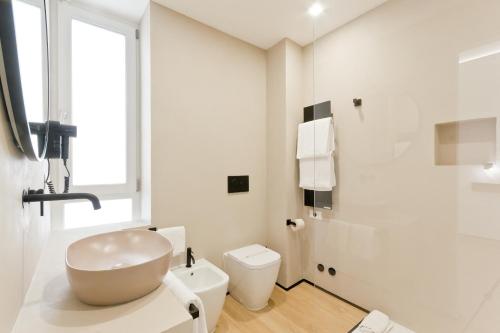 a white bathroom with a sink and a toilet at Borgo Centrale Rooms in Pescara