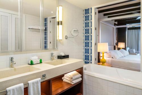 a bathroom with a tub and a sink and a bed at Ocean Riviera Paradise All Inclusive in Playa del Carmen