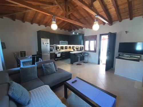 a living room with a couch and a kitchen at The Fortress, beautiful and private house with top in Skiathos Town