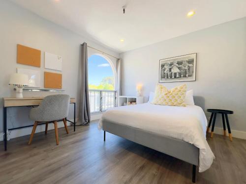 a bedroom with a bed and a desk and a window at 2 bed 2 bath penthouse condo with AC and Ocean Views in San Diego