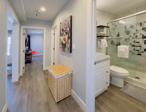 a white bathroom with a toilet and a sink at 2 bed 2 bath penthouse condo with AC and Ocean Views in San Diego