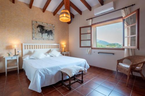 een slaapkamer met een wit bed en een raam bij Cas Colector in Selva